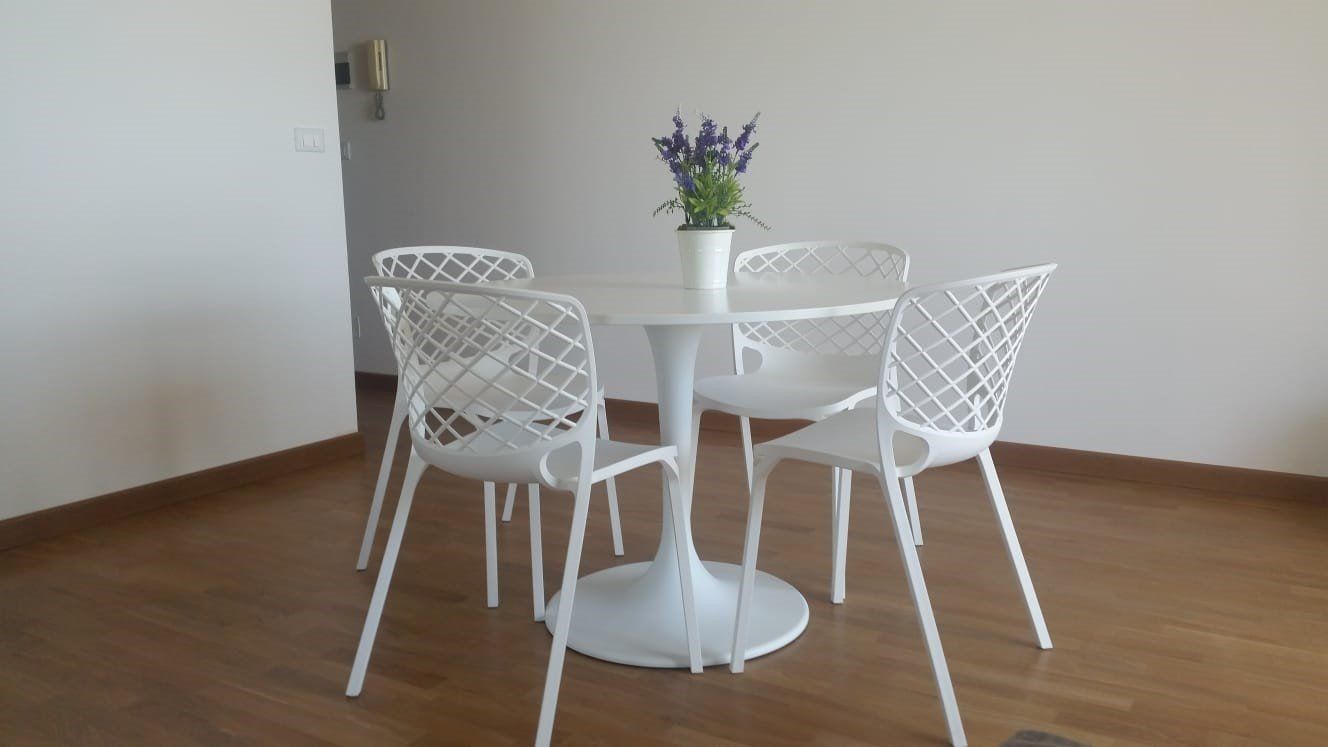 tavolo con sedie bianche su parquet scuro