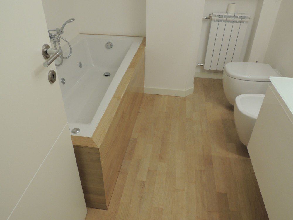 bagno con mobili e pavimenti in legno
