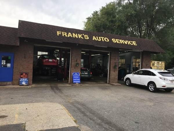Frank's Auto Service storefront with open garage bays and a white car parked outside