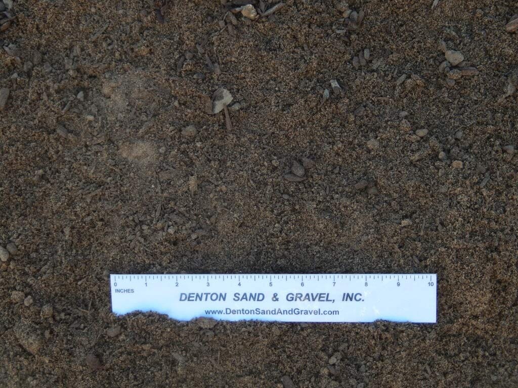 Brown sandy soil with a ruler marked in inches, from Denton Sand & Gravel, Inc.
