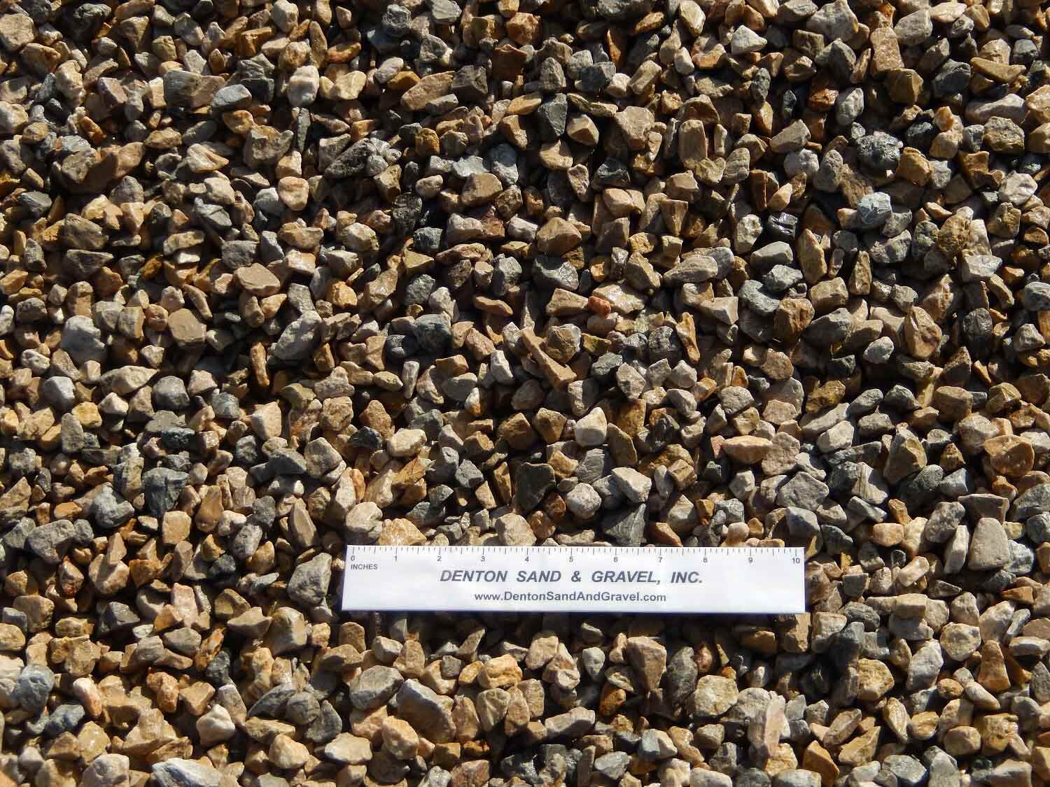 Gravel in shades of brown and gray with a ruler in the center.