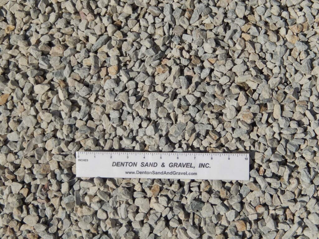 Crushed stone gravel in shades of gray, tan, and white with a ruler, from Denton Sand & Gravel.