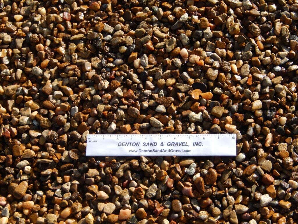Close-up of small, colorful pebbles with a ruler for scale.