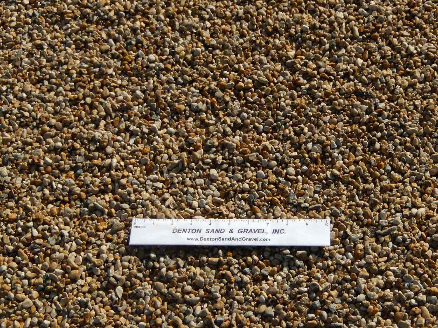 Gravel with a ruler for scale; brown and tan stones.