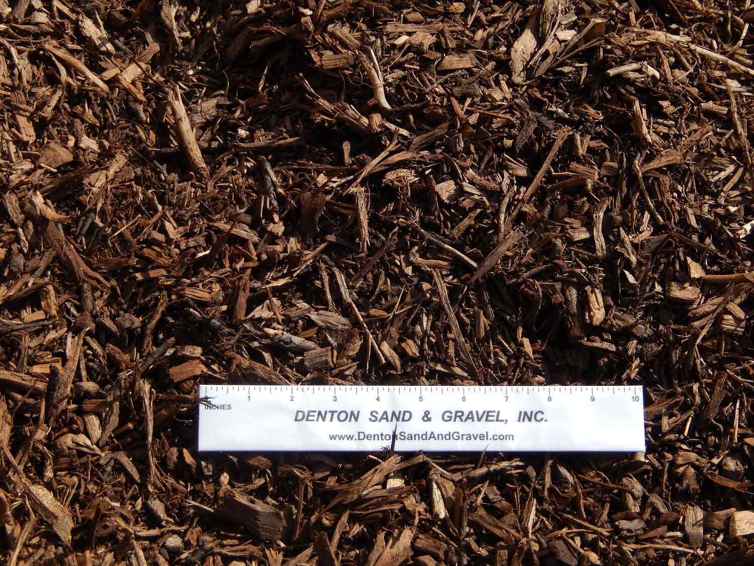Brown mulch with a white ruler on top.