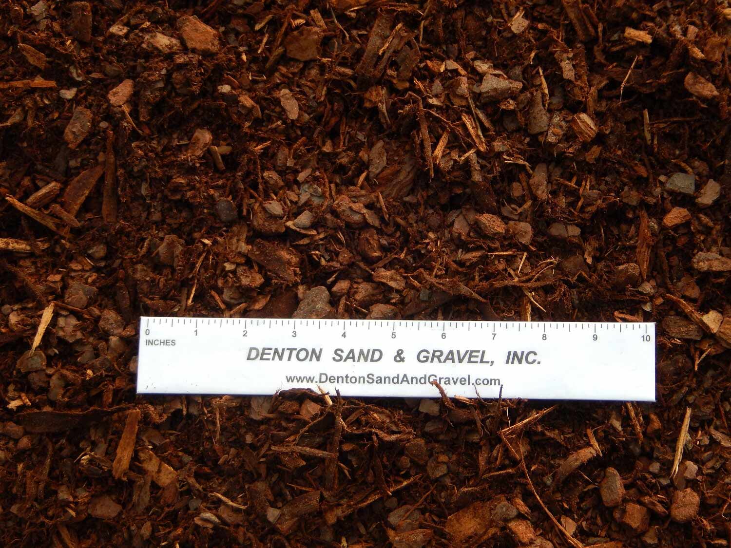 Brown mulch with a ruler across it, showing size.