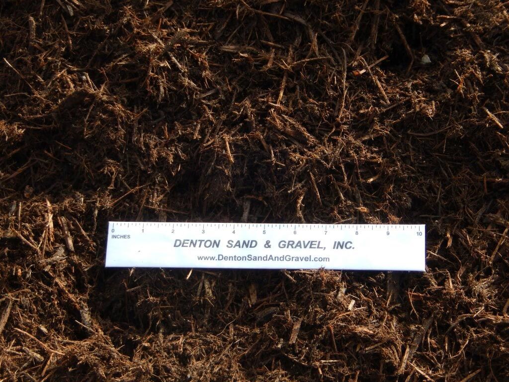 Brown mulch with a white ruler from Denton Sand & Gravel, Inc.