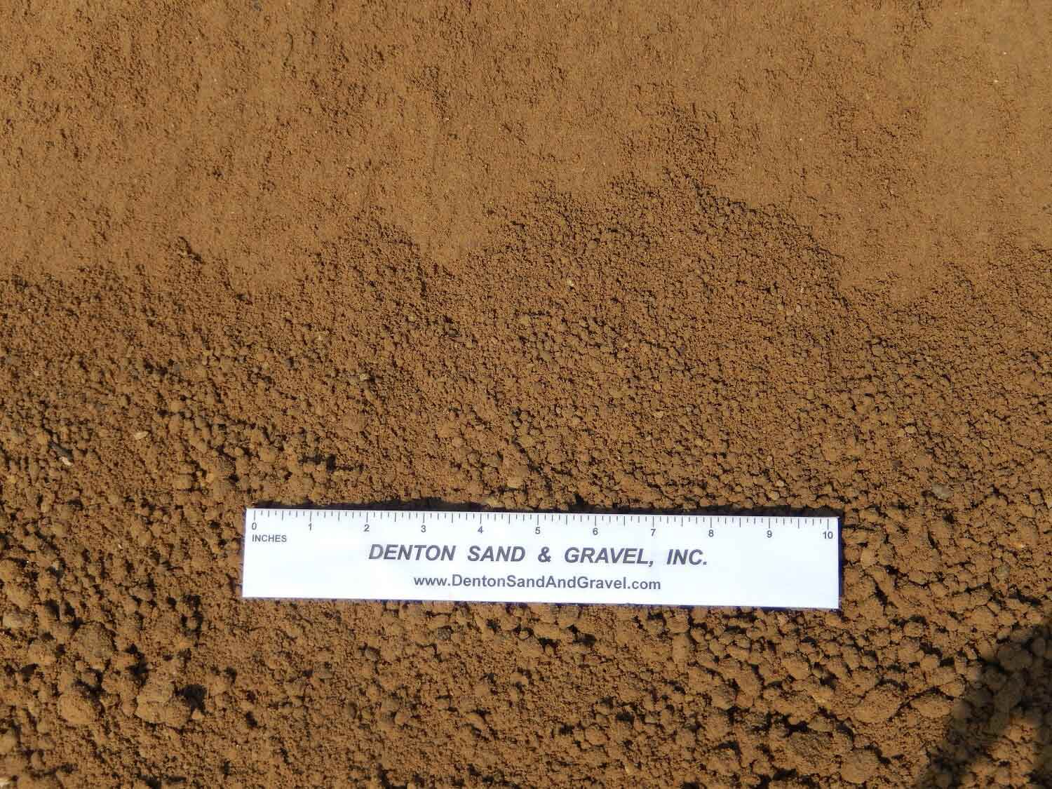 Brown sand with a ruler.