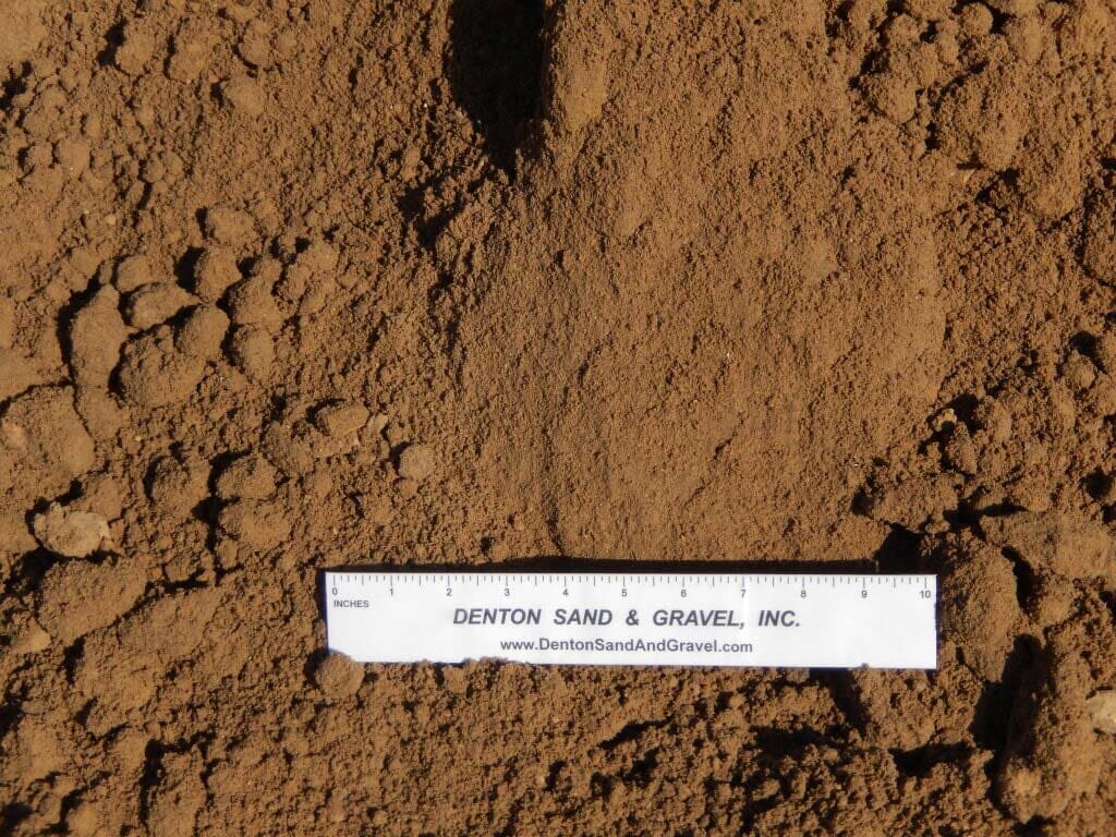 Brown sand with a ruler.