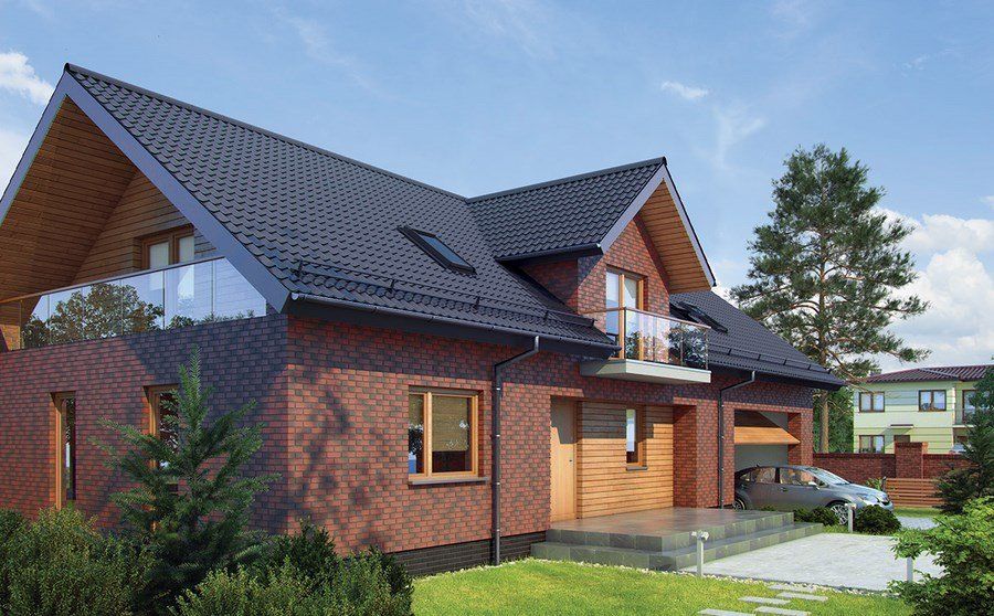 Red brick house with black roof, wooden accents, and a balcony on a sunny day.