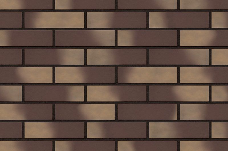 Brick wall with alternating brown and tan bricks.