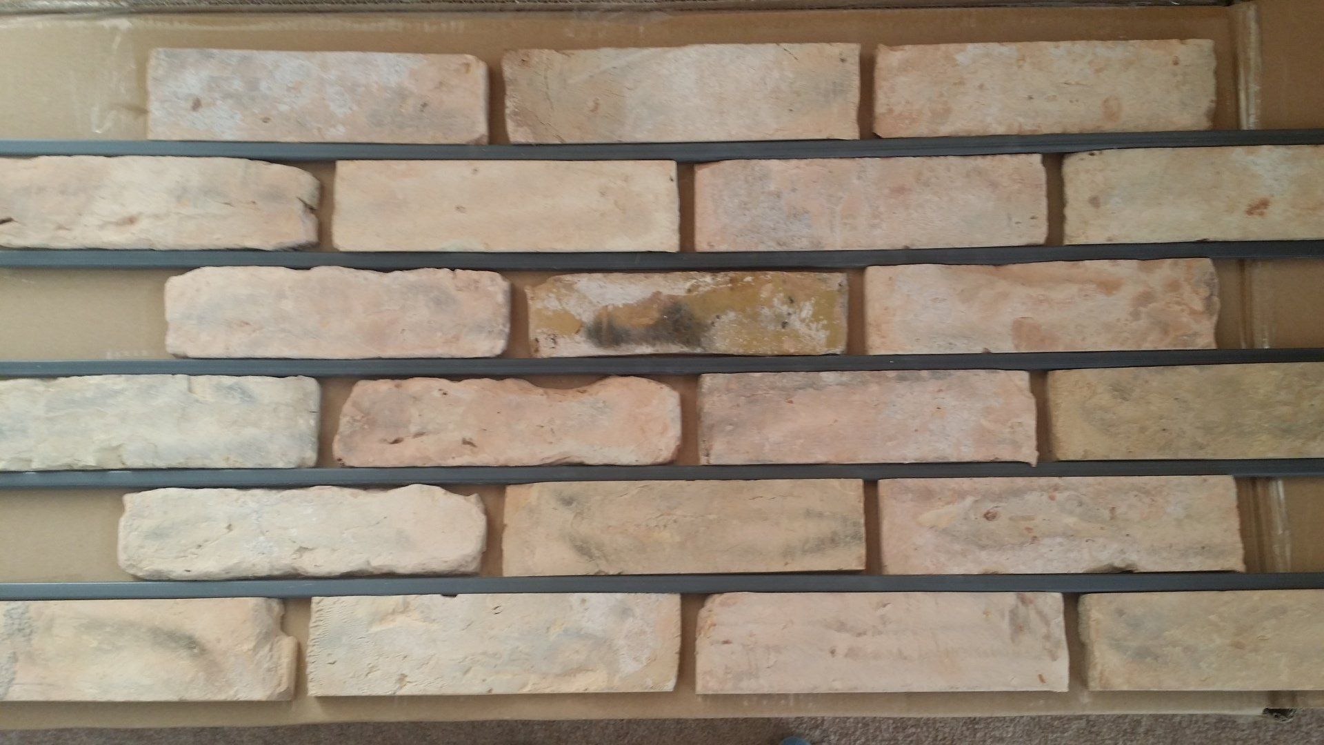 Brick wall sample with light tan bricks and dark gray mortar lines.