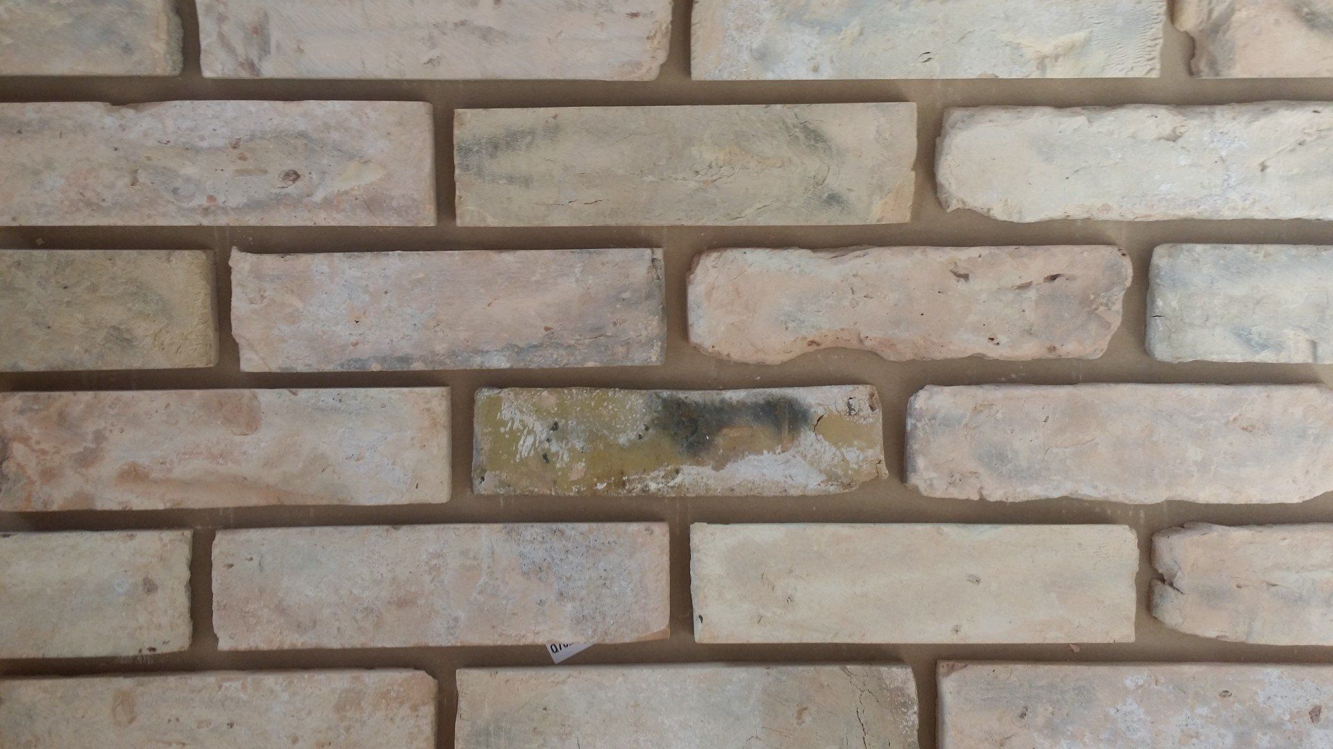 Close-up view of a brick wall, beige bricks with light brown mortar.