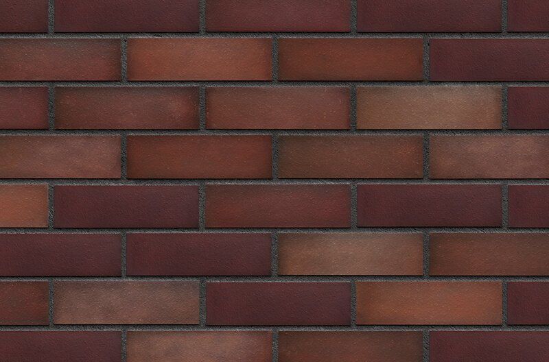 Red and brown brick wall with dark gray mortar.