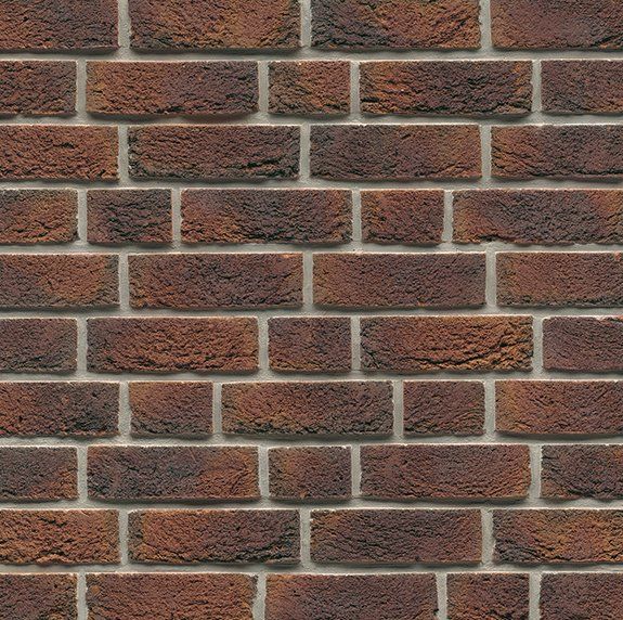 Brick wall with red and brown bricks and light gray mortar.