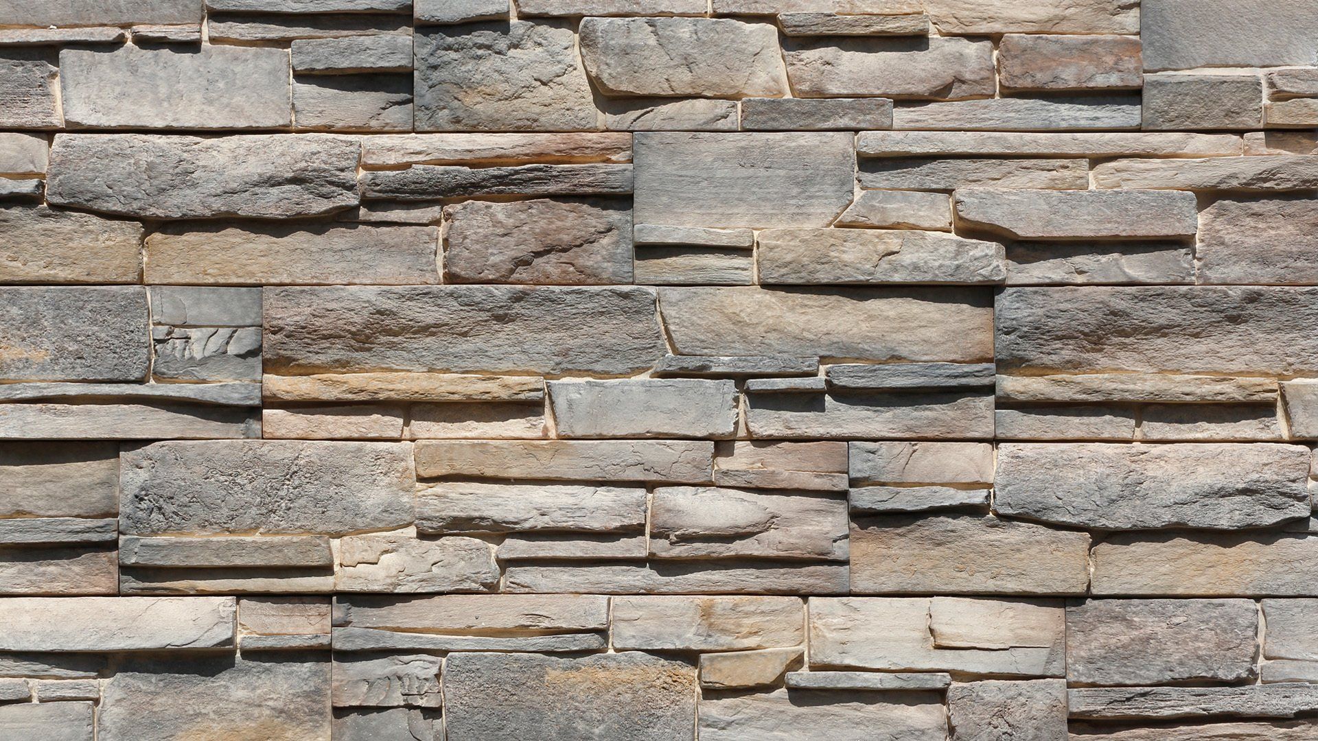 Stone wall with a textured, layered appearance; various shades of gray and tan.