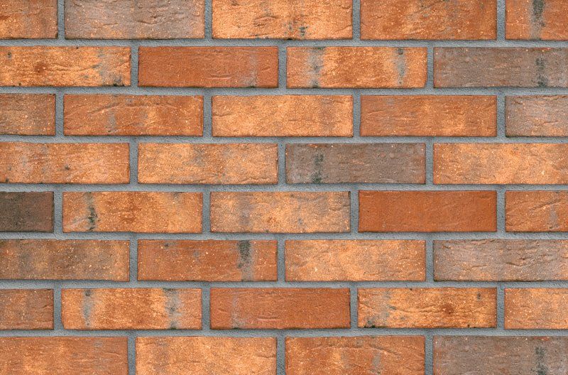 Brick wall with orange and brown bricks.