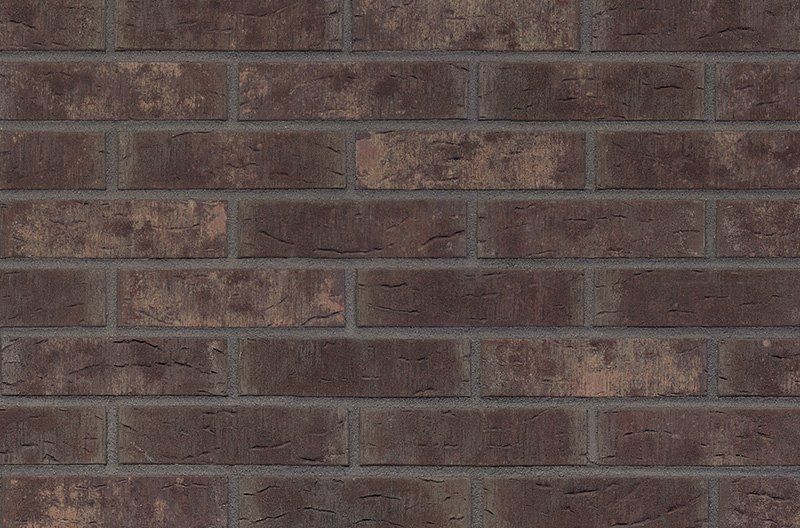 Brick wall with dark brown bricks and gray mortar.