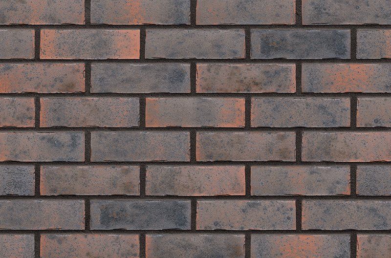 Brick wall with alternating rows of gray and reddish-brown bricks, dark mortar.