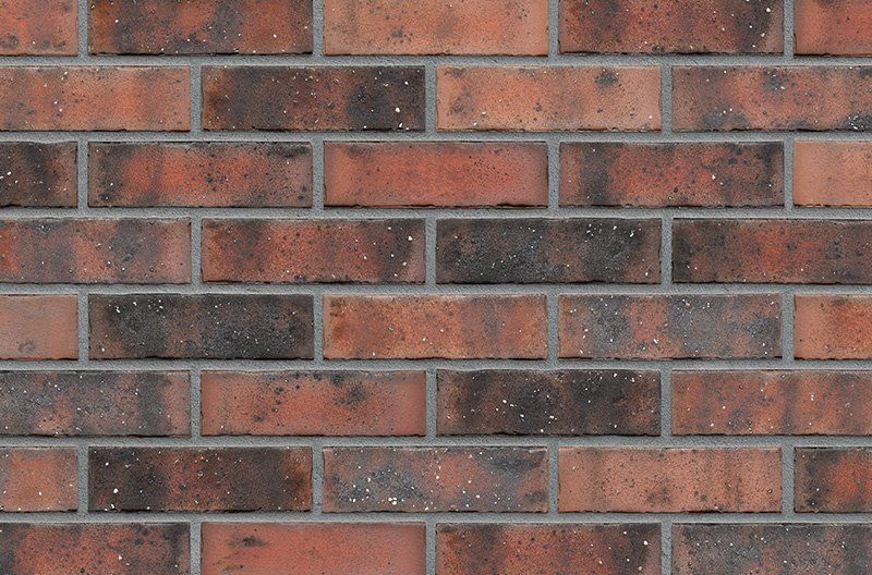 Red brick wall with dark brown and light red bricks, gray mortar.