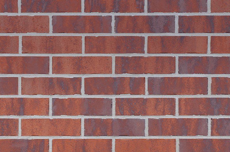 Brick wall with red-brown bricks and white mortar.