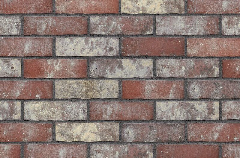 Red and tan brick wall with dark mortar.