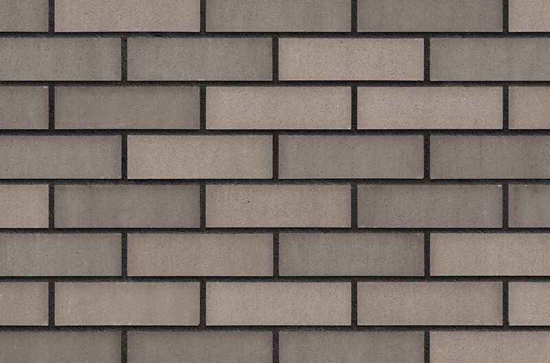 Gray and tan brick wall with dark grout lines.