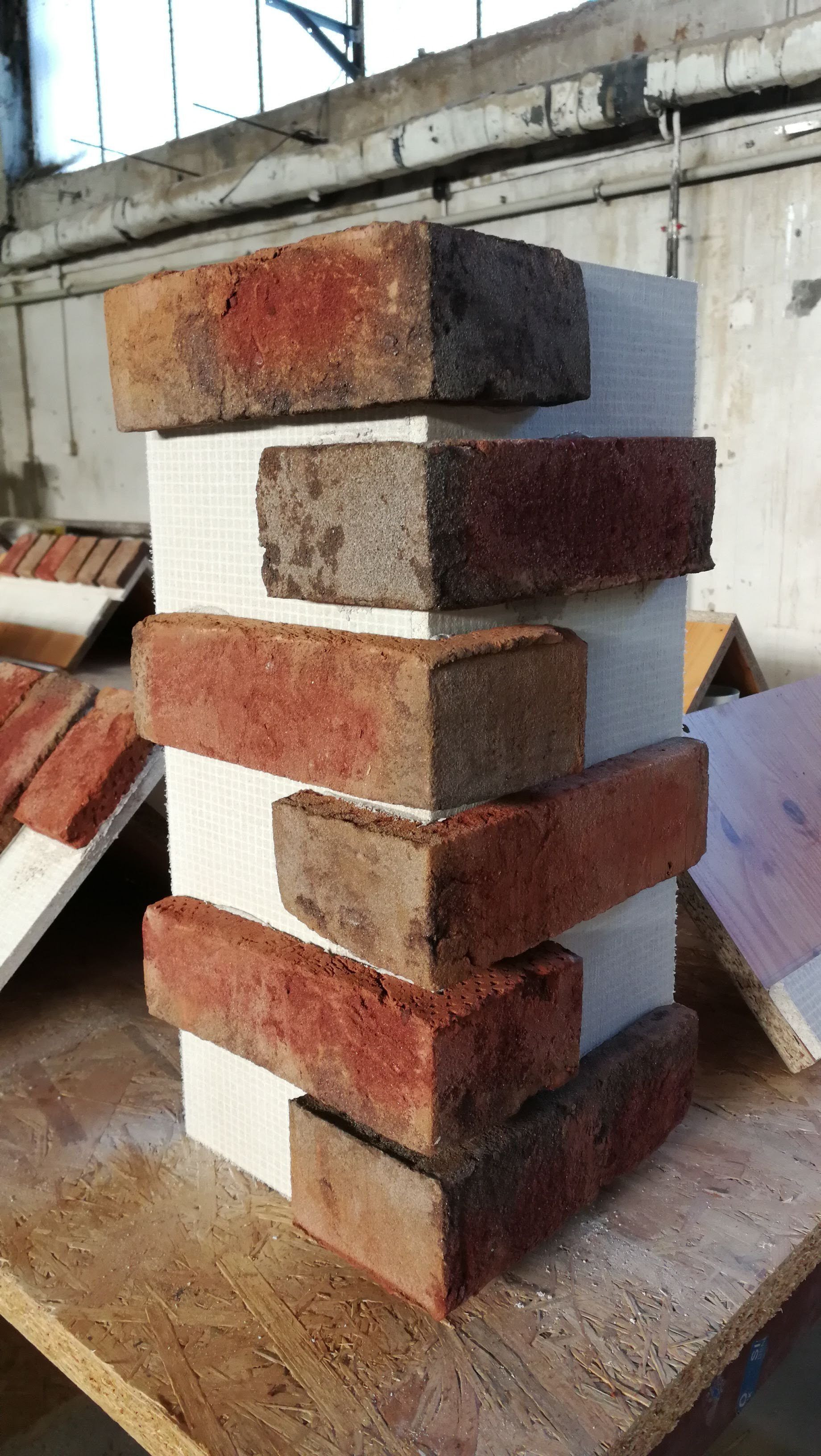 Corner brick sample with red and brown bricks on a white backing.