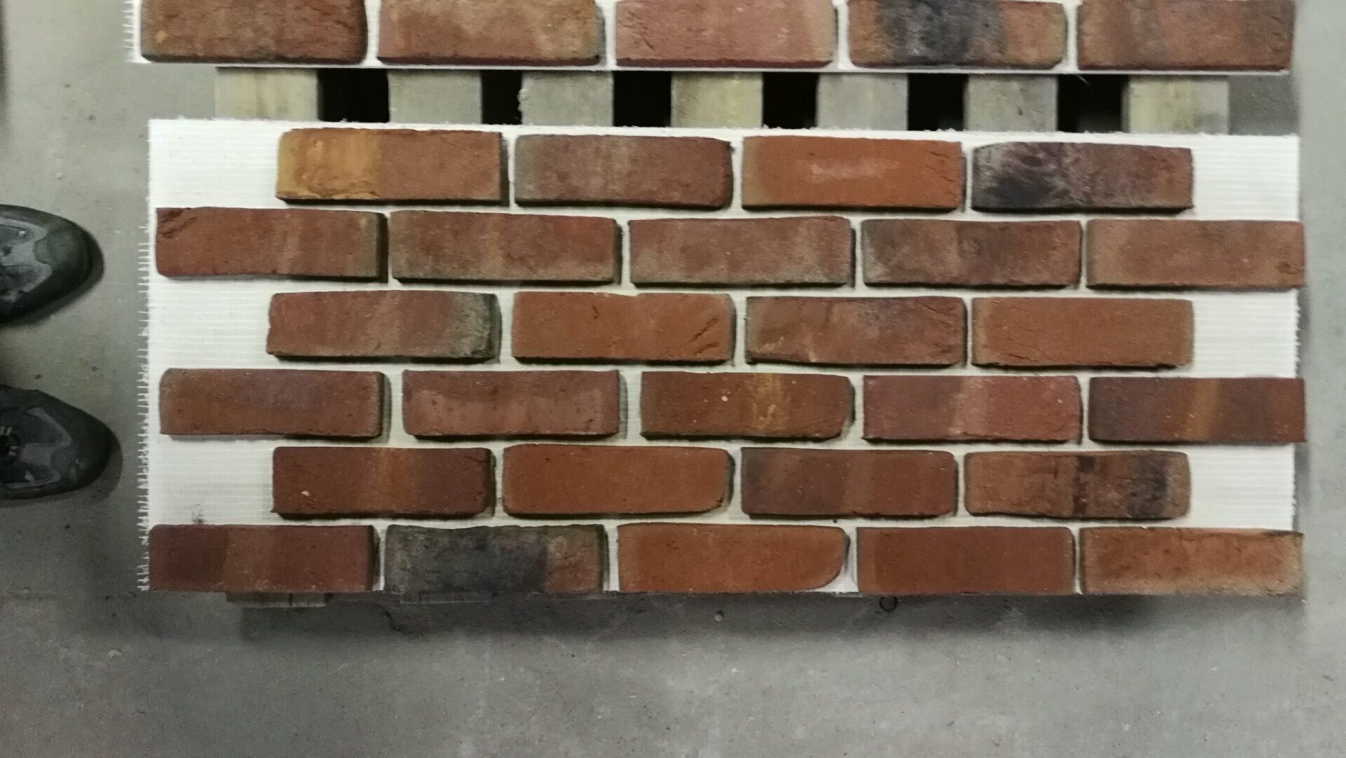 Brick samples on a white backing, showing different color variations in a running bond pattern.