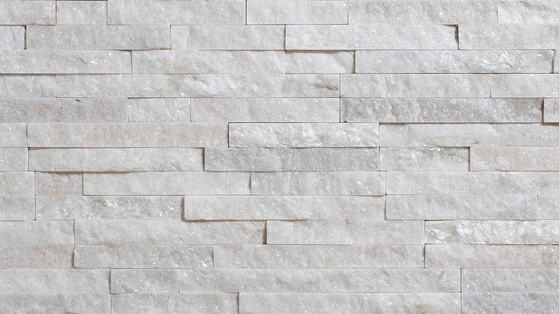 White stacked stone wall with varying rectangular shapes.