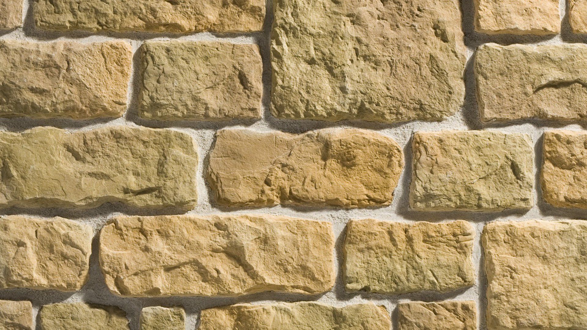 Close-up view of a stone wall, featuring beige and tan rectangular stones with gray mortar.
