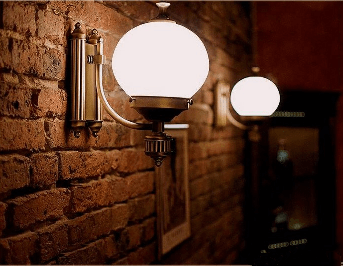 Two globe-shaped lights mounted on a brick wall, casting a warm glow.