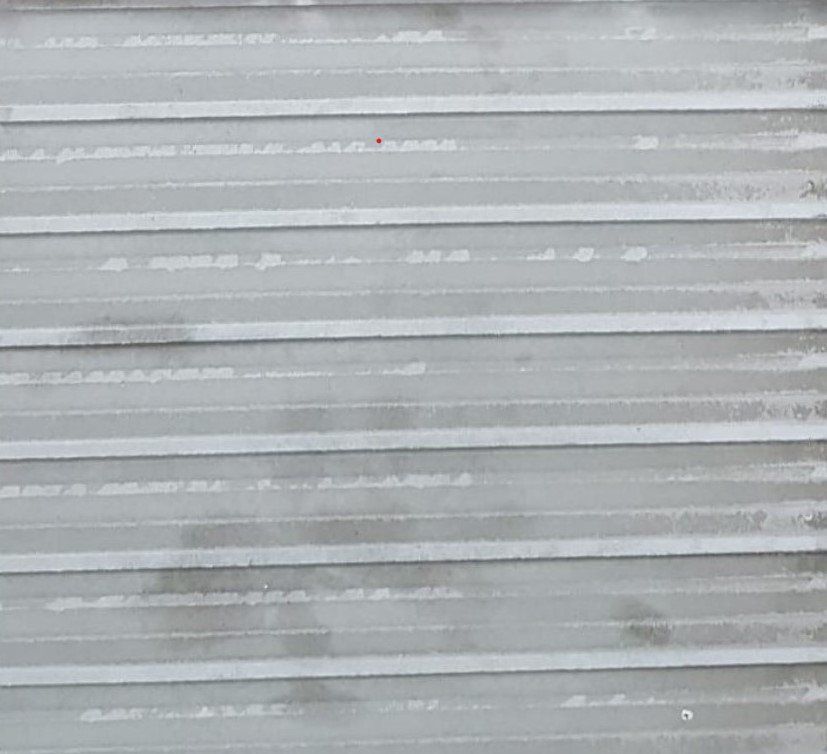 Gray corrugated metal siding, showing horizontal ridges.