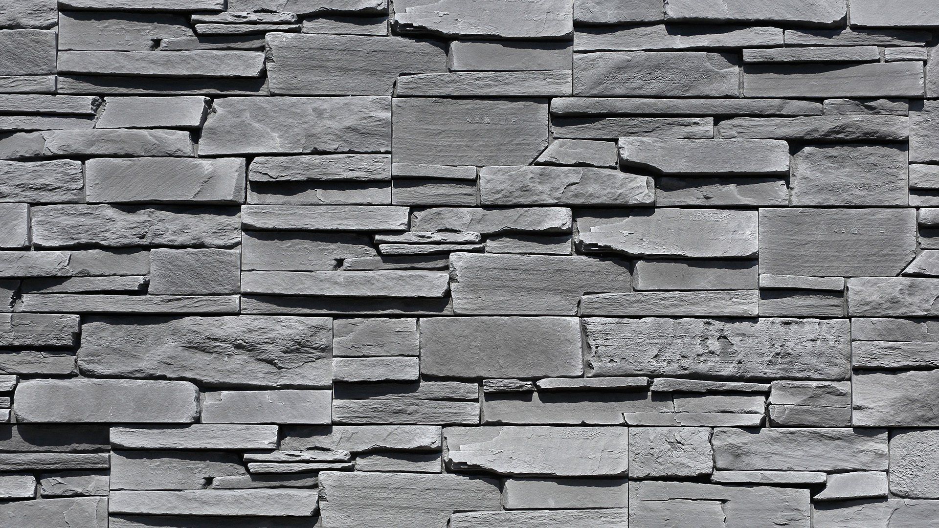 Gray stone veneer wall with stacked rectangular shapes.