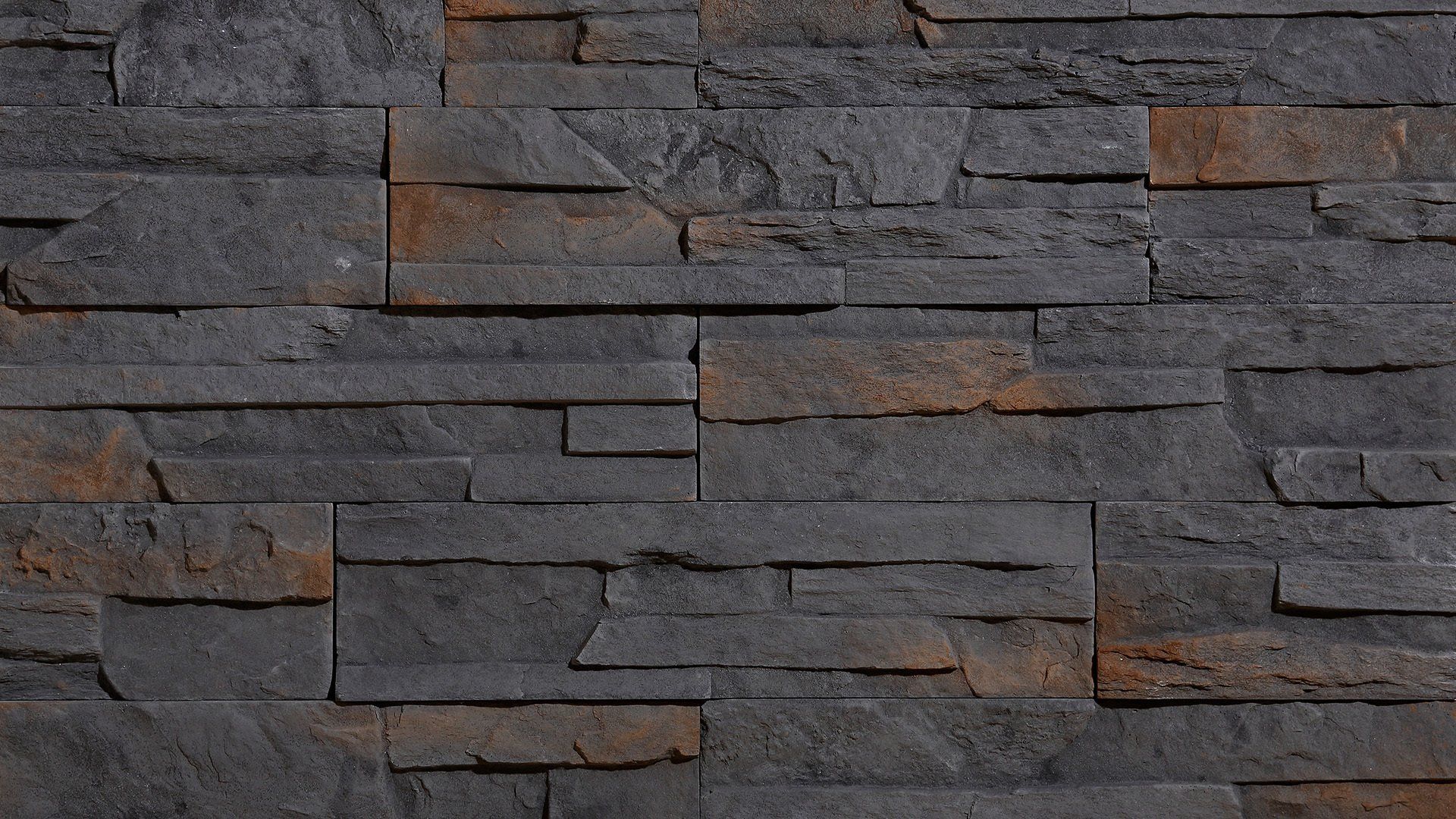 Dark gray and brown stacked stone wall.