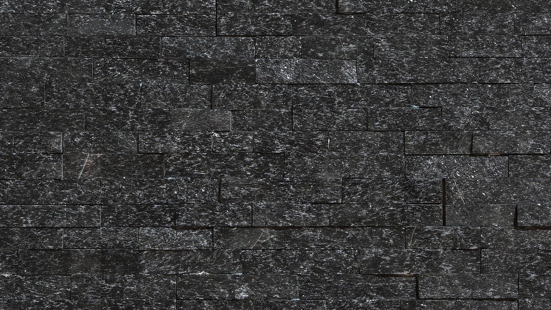 Black stone wall with speckled texture.