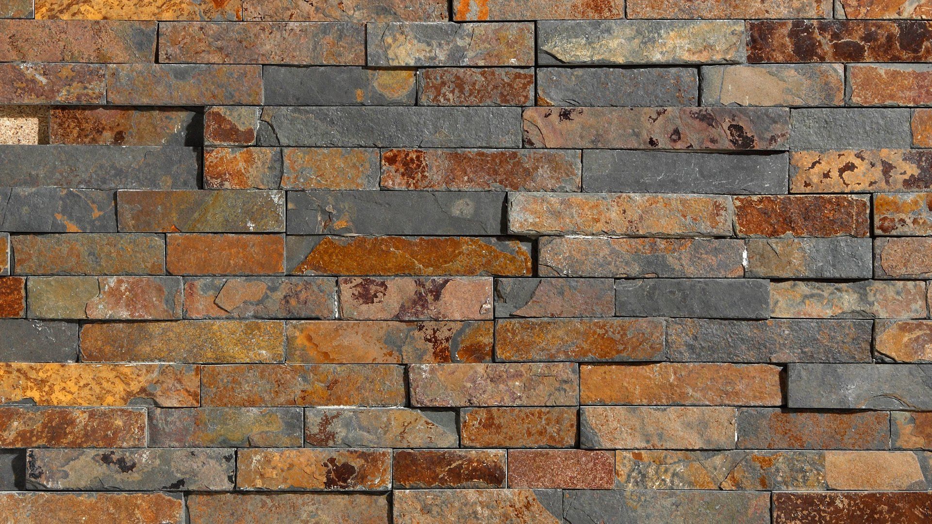 Rustic brick wall with varying shades of brown, orange, and gray.
