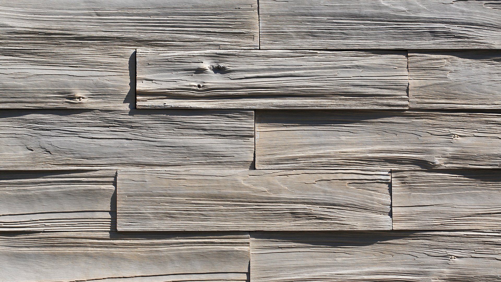 Gray and tan rectangular stone tiles arranged in a stacked pattern, with textured, weathered look.