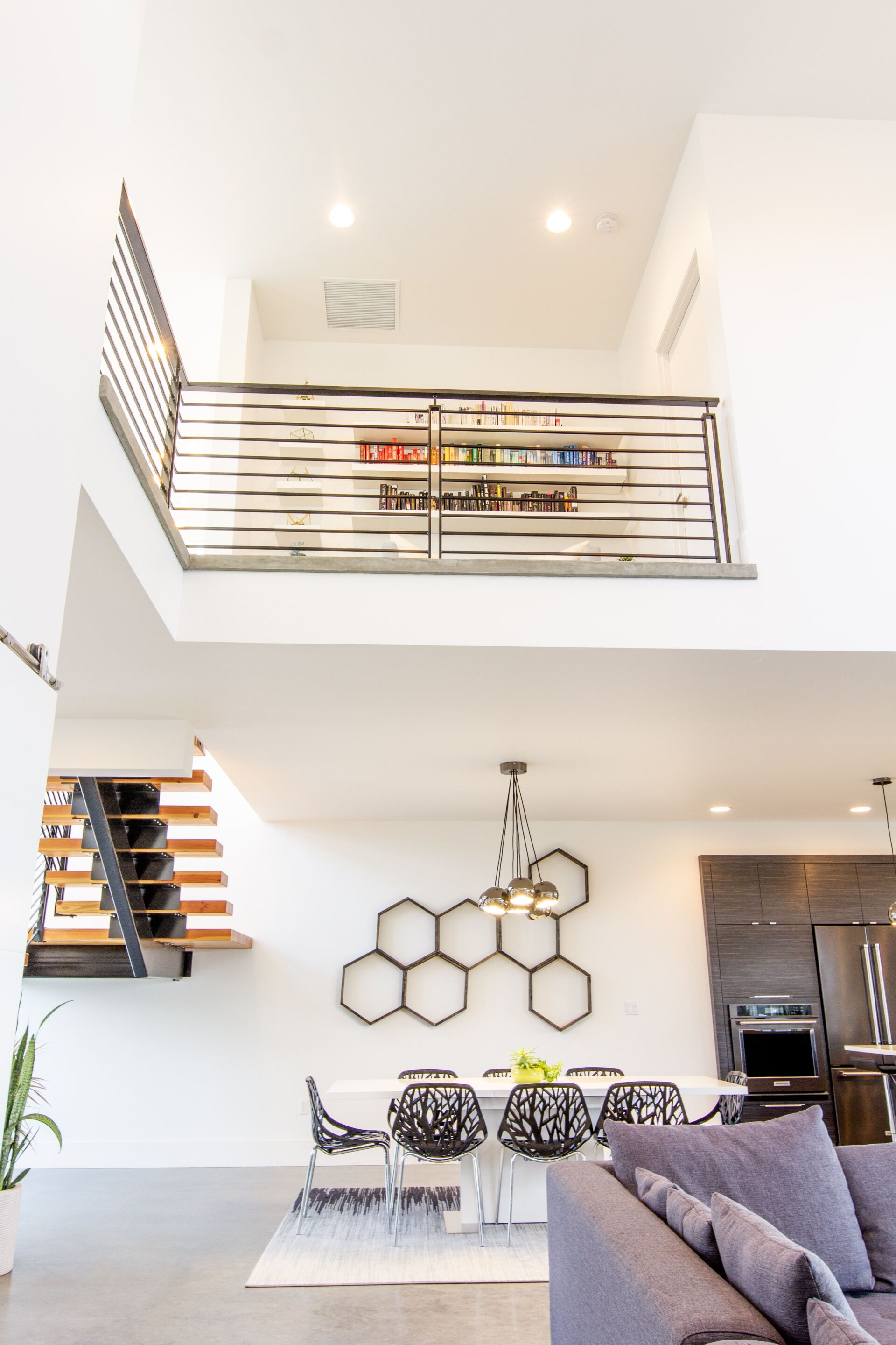 A living room with a couch , table and chairs and a balcony.