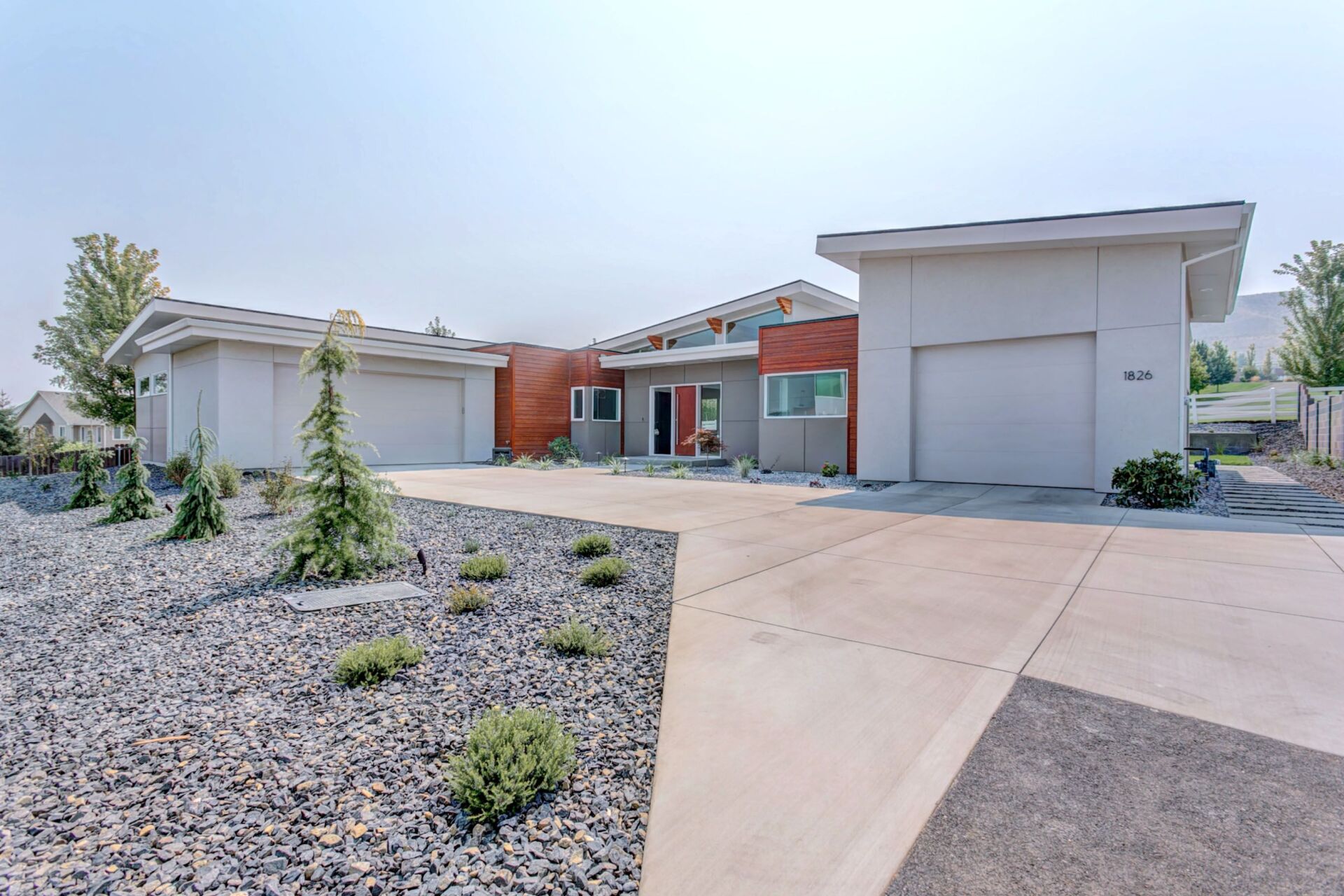 A modern house with a driveway and garages