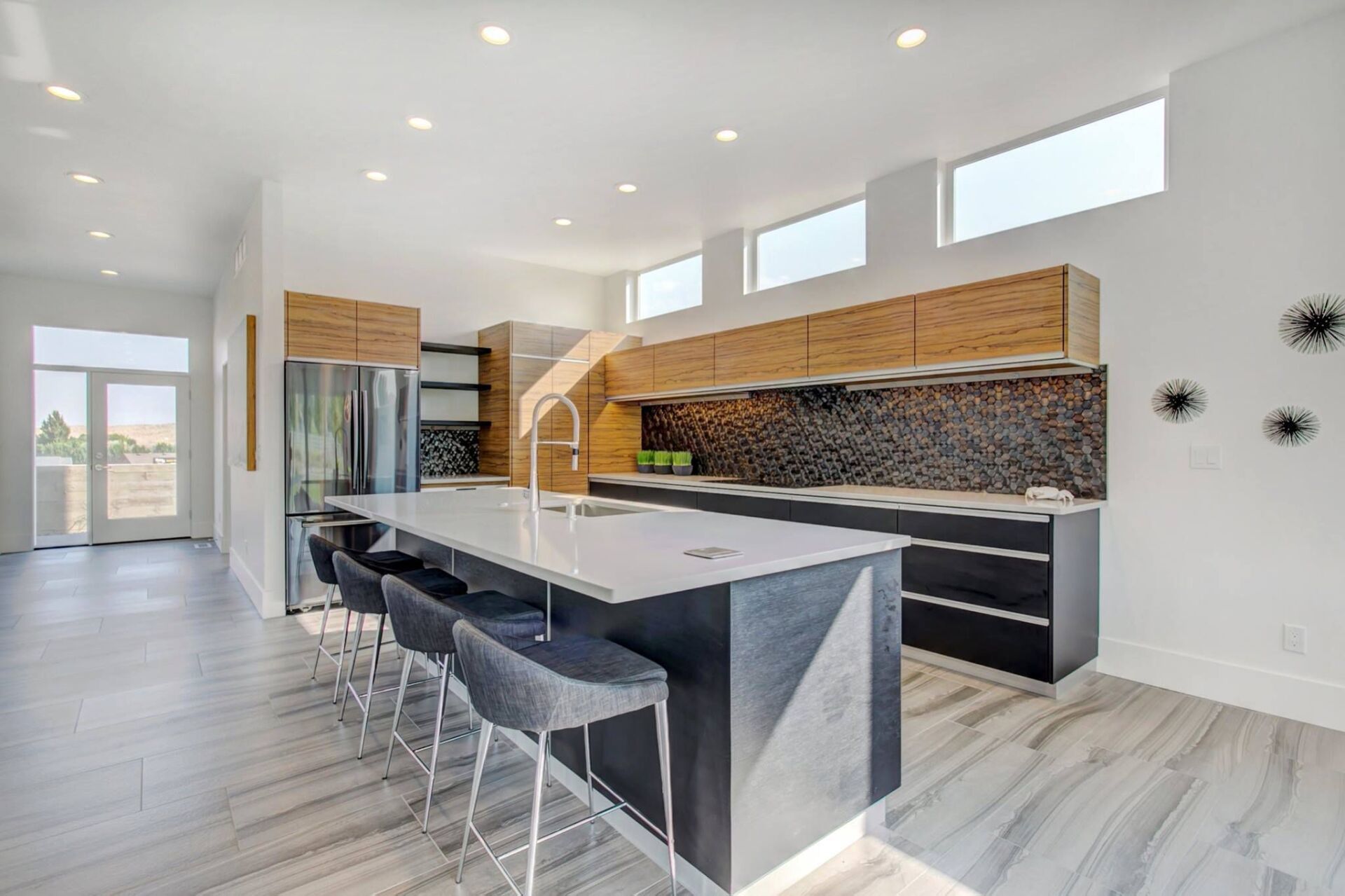 A modern kitchen with a large island and stools.