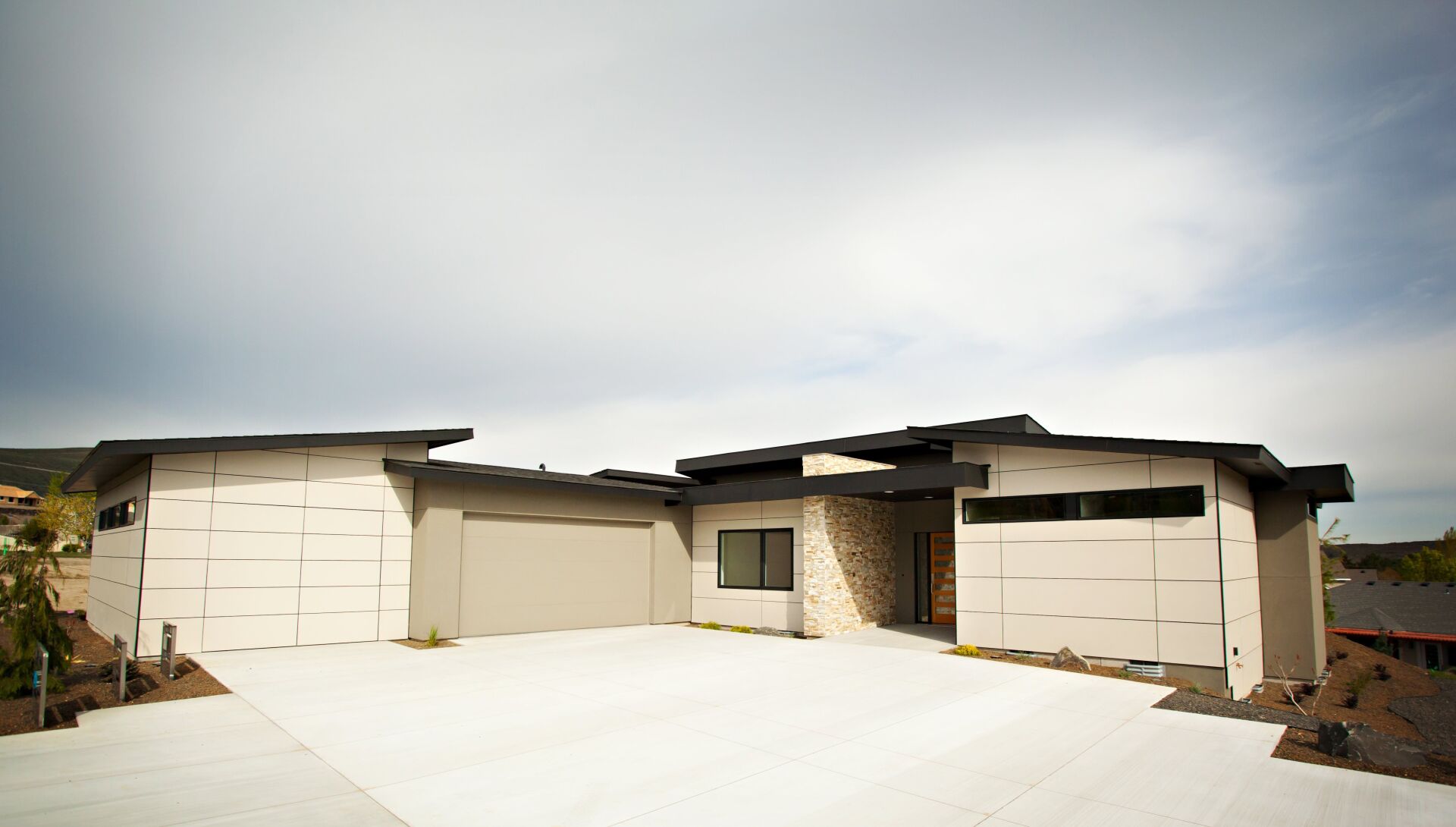 A large white house with a concrete driveway in front of it.