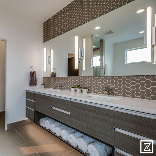 A bathroom with two sinks and a large mirror