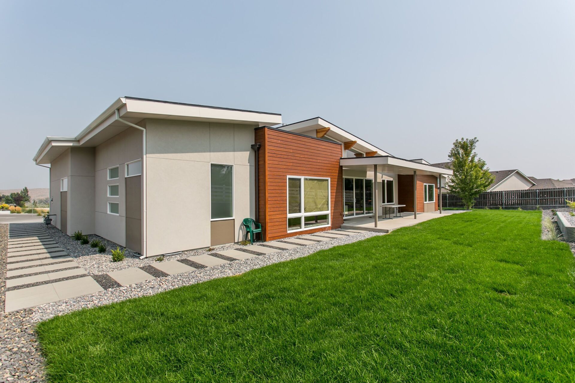 A modern house with a large lawn in front of it.