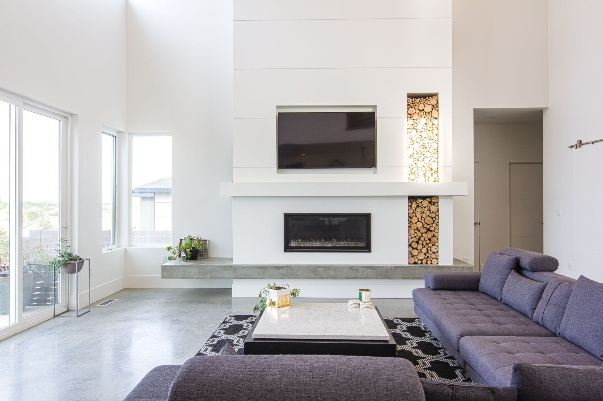 A living room with a fireplace , couch , coffee table and television.