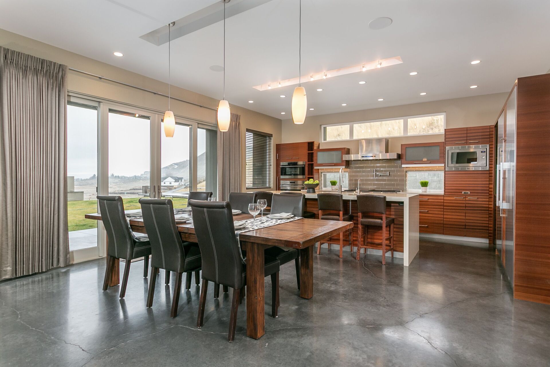 A large dining room with a table and chairs and a kitchen.