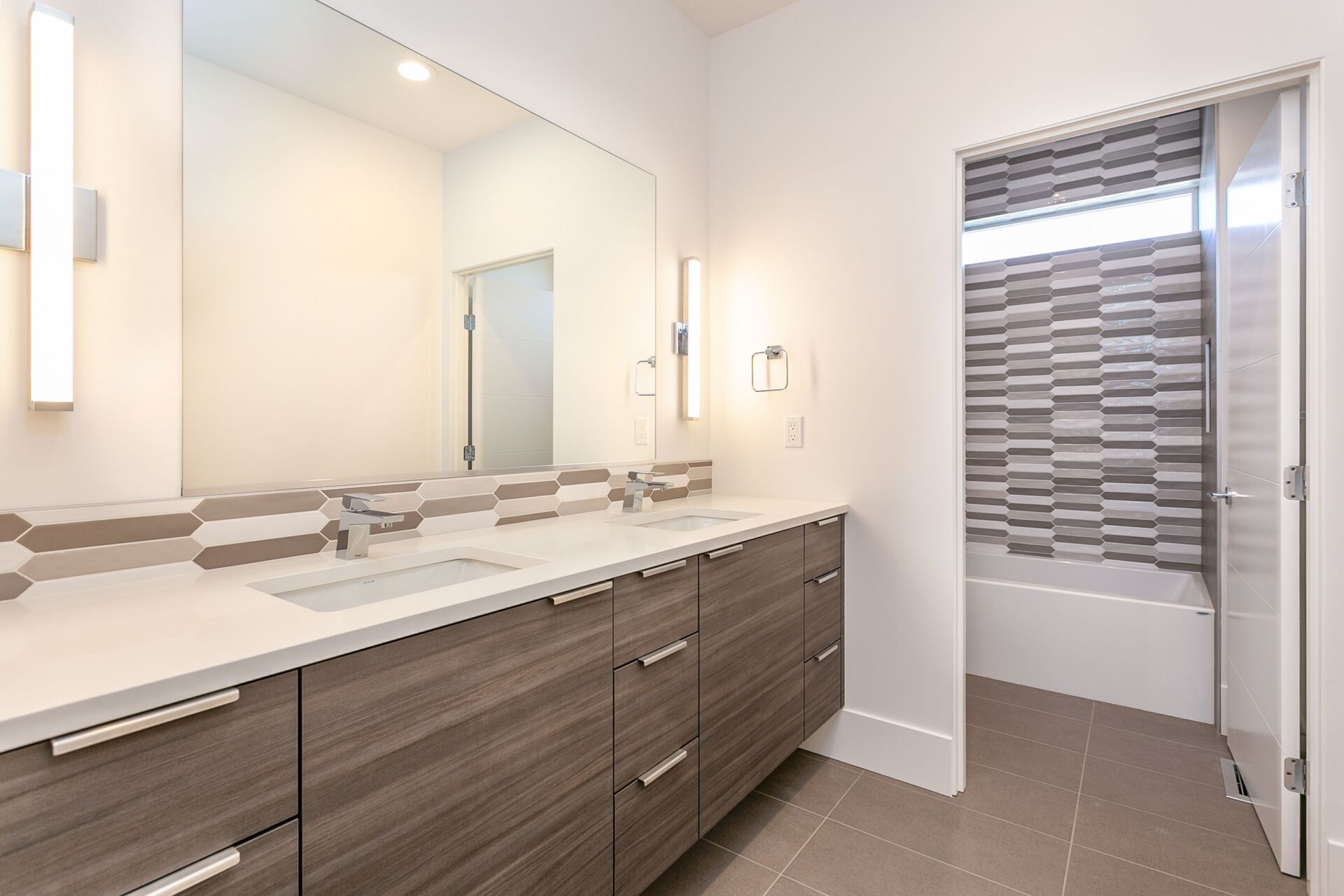 A bathroom with two sinks and a large mirror.