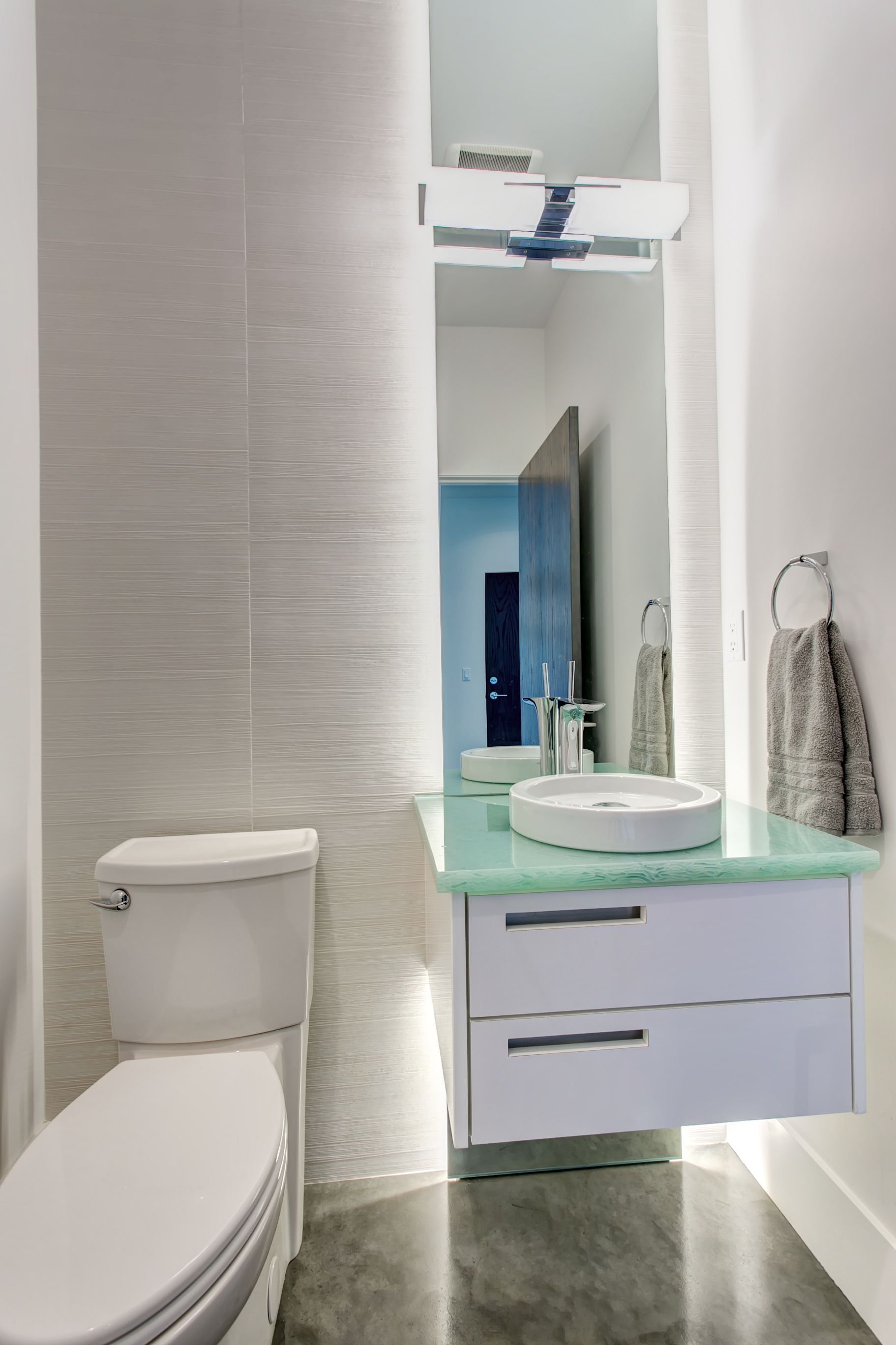 A bathroom with a toilet , sink and mirror