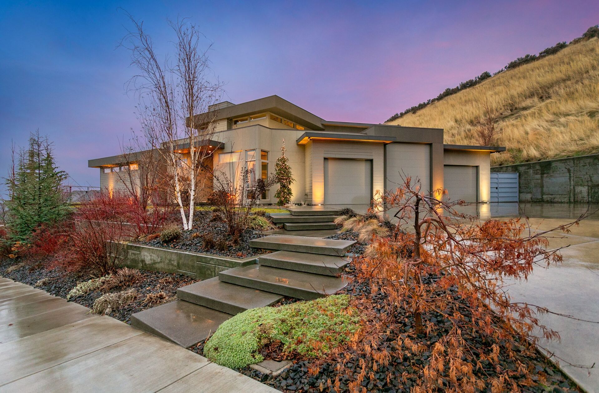 A large house with stairs leading up to it is sitting on top of a hill.