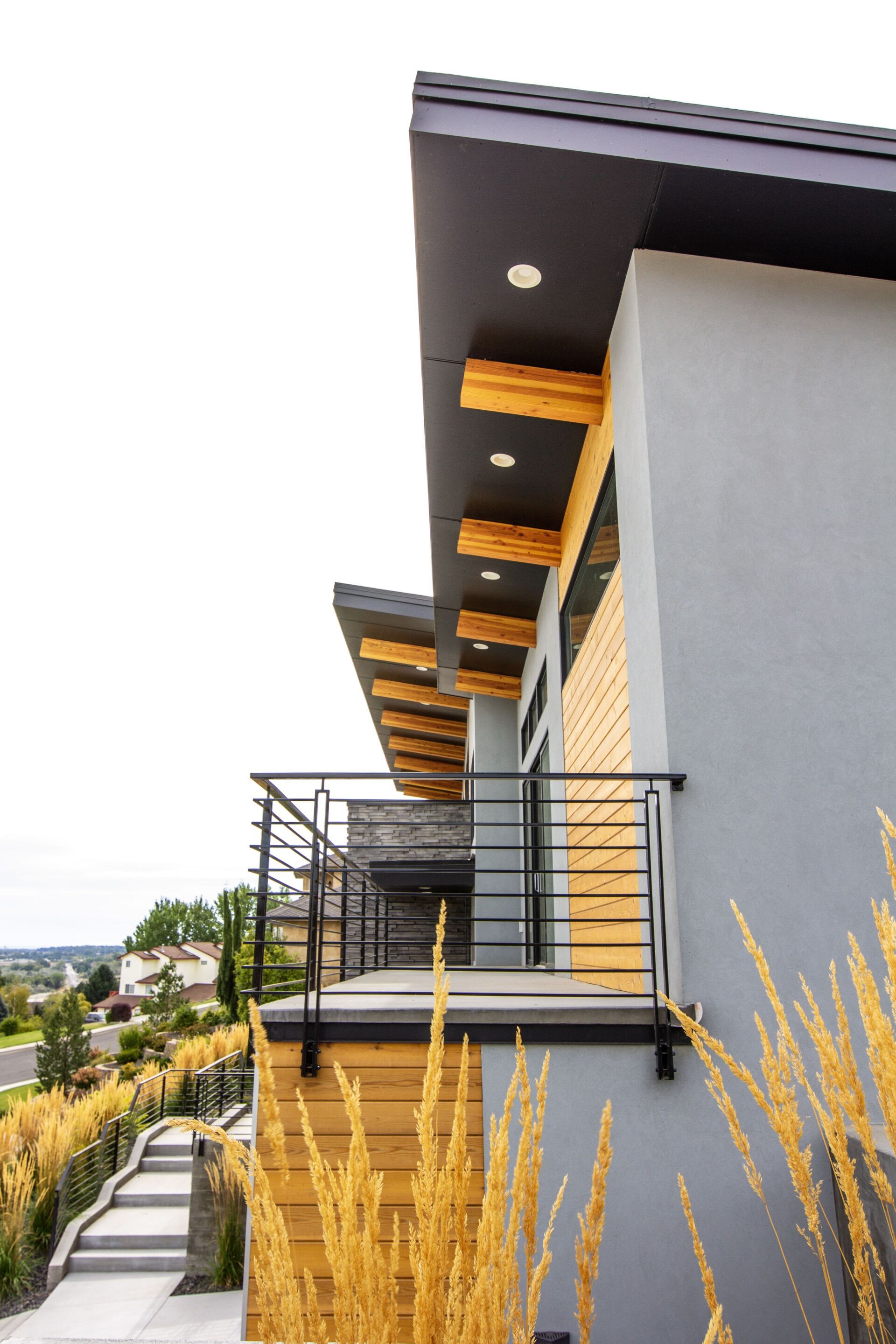 A modern house with a balcony and stairs leading up to it.
